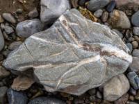 Eckiger grauer Stein mit weißen Vertiefungsrillen